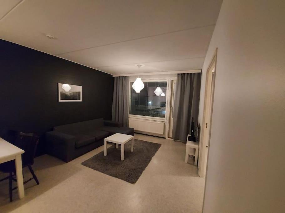 uma sala de estar com um sofá e uma mesa em Saunallinen kaksio em Tampere