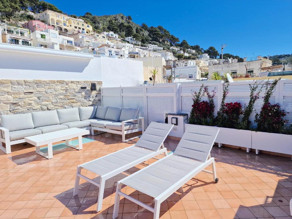 d'une terrasse avec 2 chaises blanches et un canapé. dans l'établissement La Chiocciola, à Capri