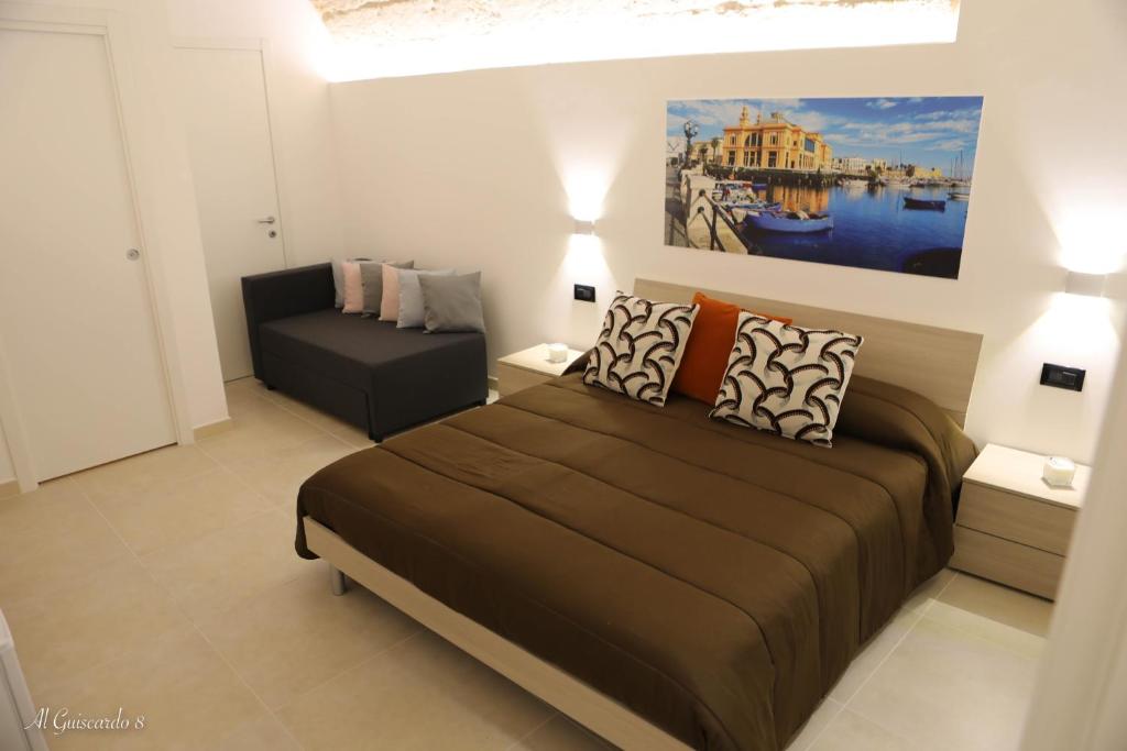 a bedroom with a bed and a couch in it at Al Guiscardo 8 in Bari
