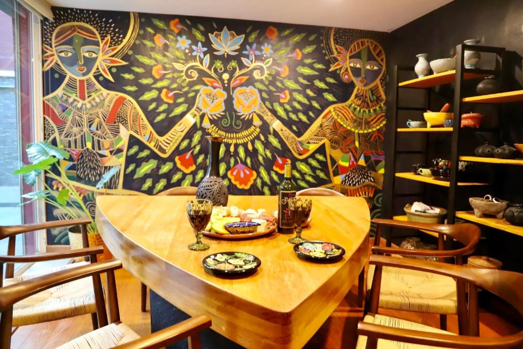 Luxurious Mid Century Modern folk art home في مدينة ميكسيكو: طاولة في غرفة مع لوحة على الحائط
