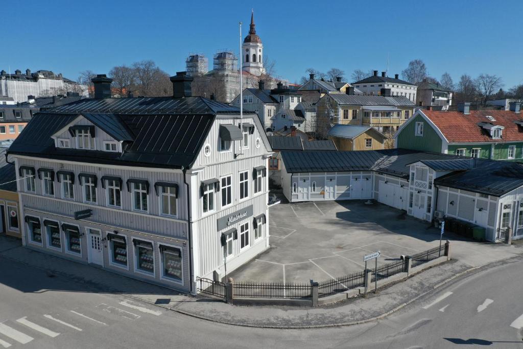 ein großes weißes Gebäude mit einem Parkplatz in einer Stadt in der Unterkunft Centrala lägenheter med allt som behövs! in Härnösand