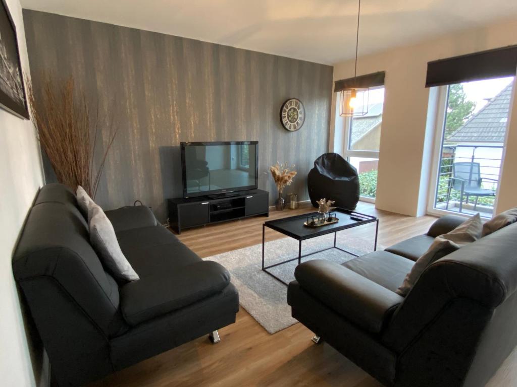a living room with two couches and a television at Ferienwohnung Nahe der Nordsee in Hemmingstedt