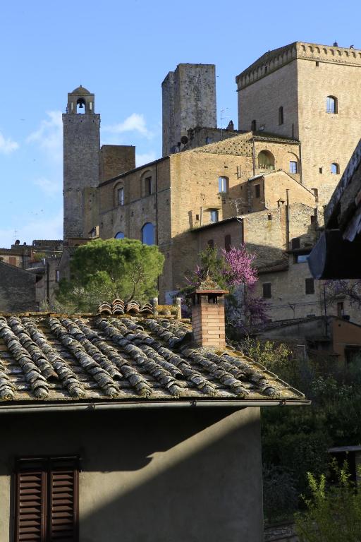 Blick auf eine Burg vom Dach eines Gebäudes in der Unterkunft La casa di Ines in San Gimignano
