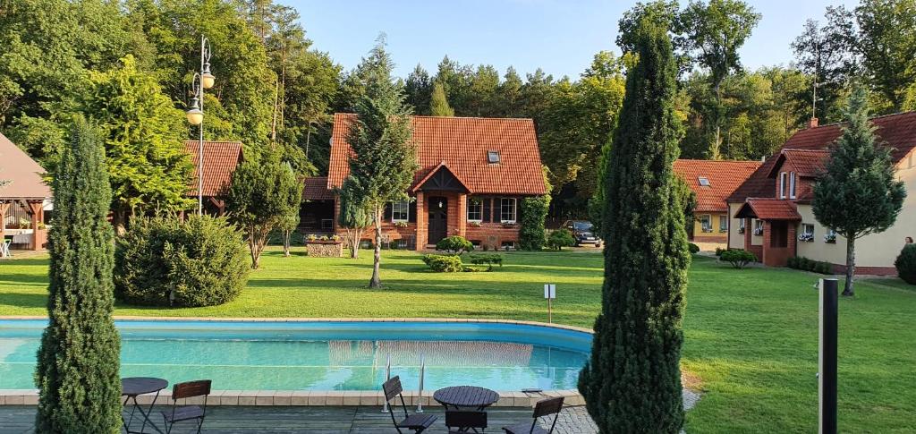 una casa con piscina en un patio en Leśniczówka "Przyłęsko" en Rybakowo