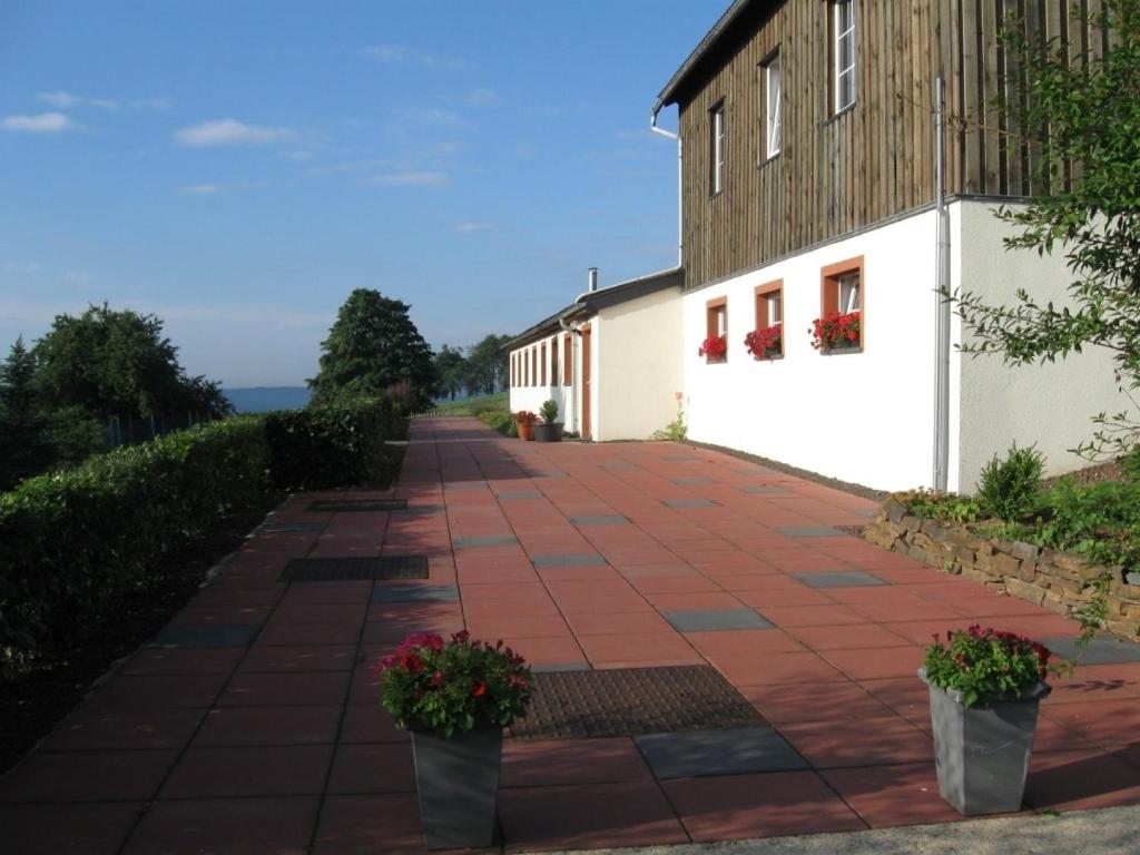 uma passarela de tijolos ao lado de um edifício com flores em Groepsverblijf Snowview Lodge em Medendorf
