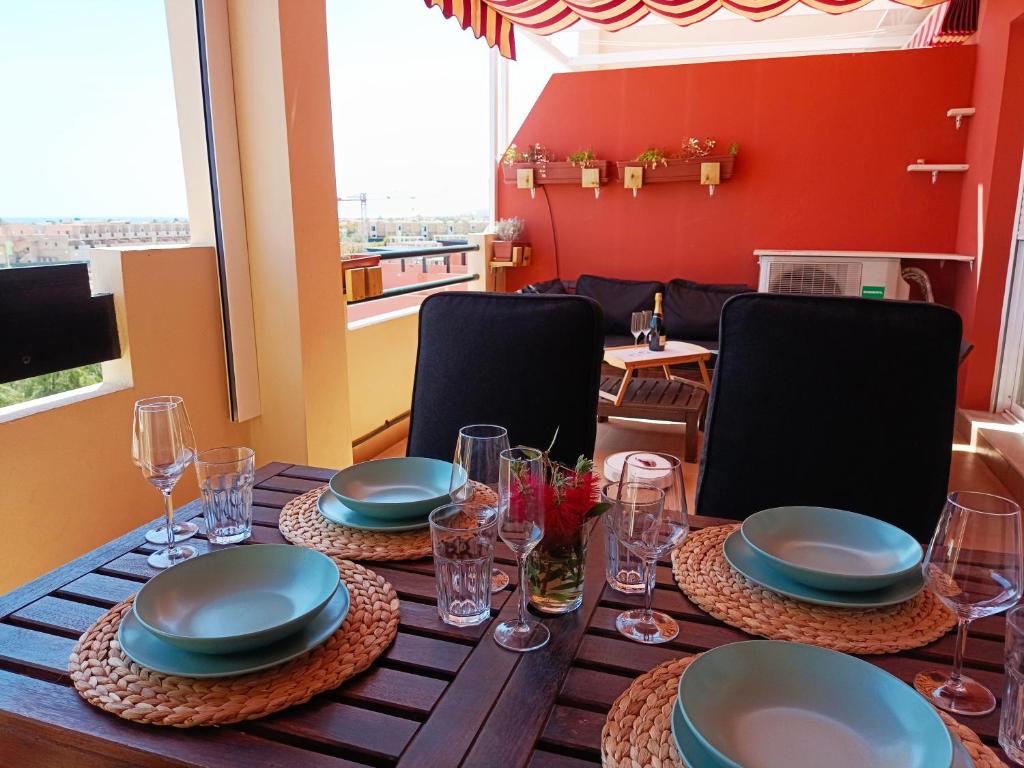 a dining room table with plates and glasses on it at La Terraza del Gallopedro in Vera