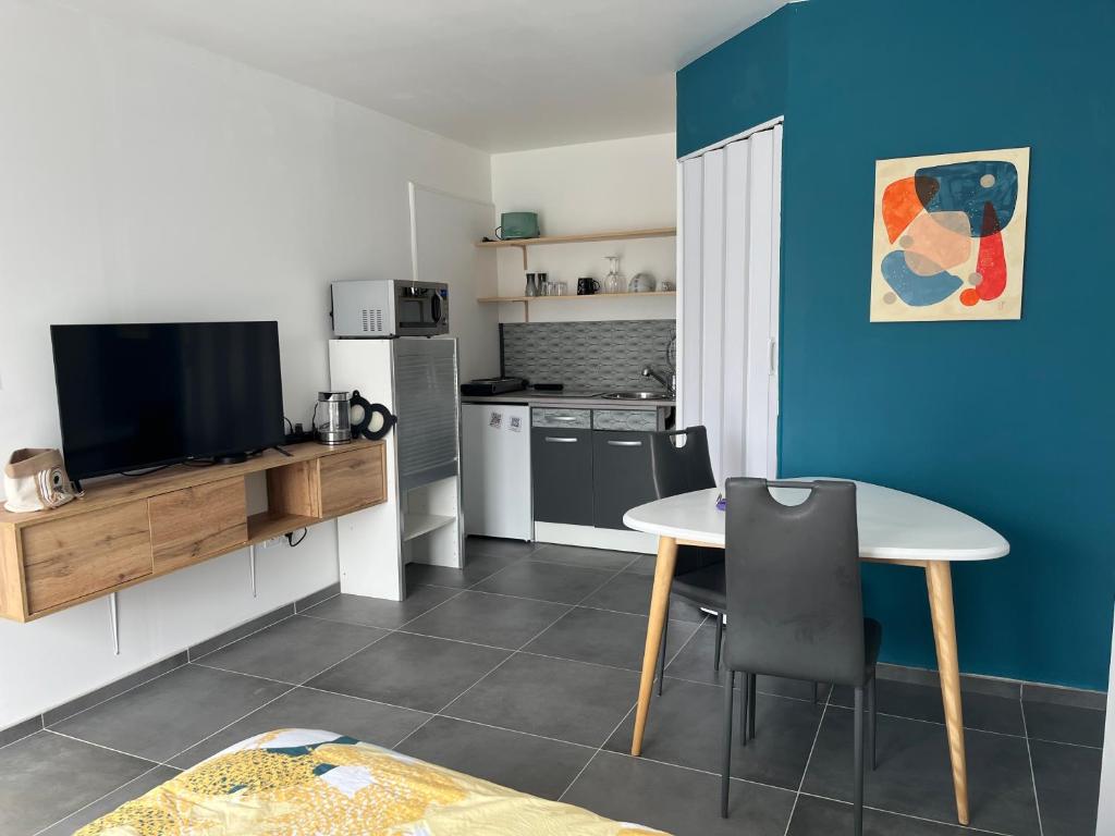 - une cuisine avec une table et une télévision dans la chambre dans l'établissement Blu'in - Mérignies, à Mérignies