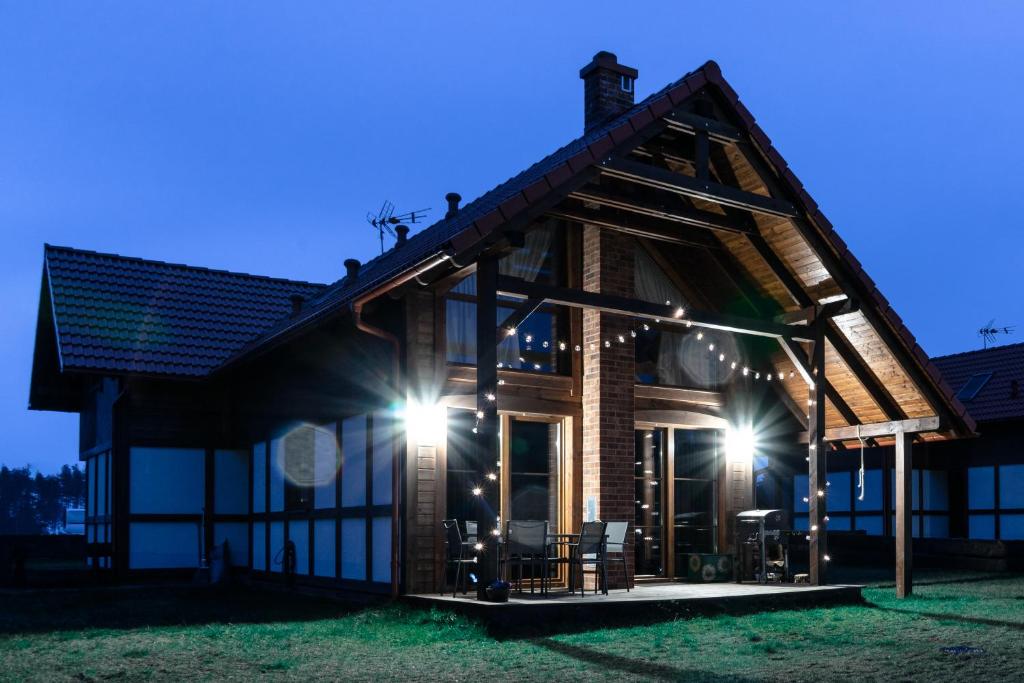una casa de madera con luces en la parte delantera en Rozmaryn - Komfortowy domek całoroczny na Kaszubach, en Borowy Młyn