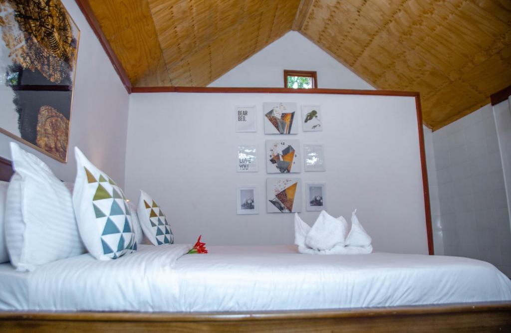 a bedroom with a white bed in a room at Shose Farm House & Chalets in Moshi