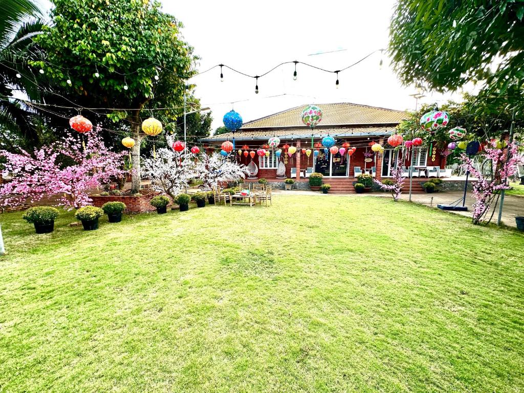 un patio con una casa con globos y flores en Family Garden House at Tri An Lake, Đồng Nai, en Ðồng Sài