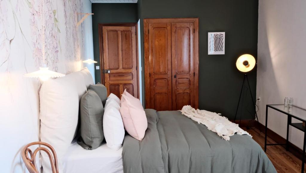 ein Schlafzimmer mit einem Bett mit Kissen darauf in der Unterkunft Un air de campagne à Baudival in Le Cateau