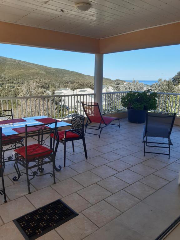 eine Terrasse mit Tischen und Stühlen und Meerblick in der Unterkunft Villa 180° C de vue imprenable in Sisco