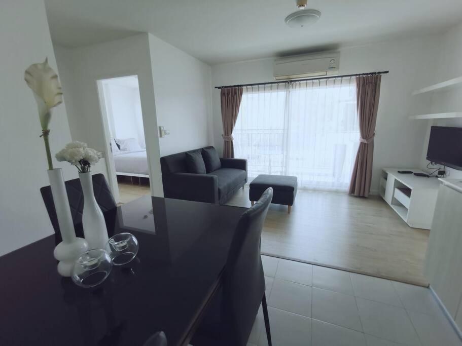 Luxury 2 bedrooms condo in Kho Takiab في هوا هين: غرفة معيشة مع طاولة طعام وغرفة معيشة