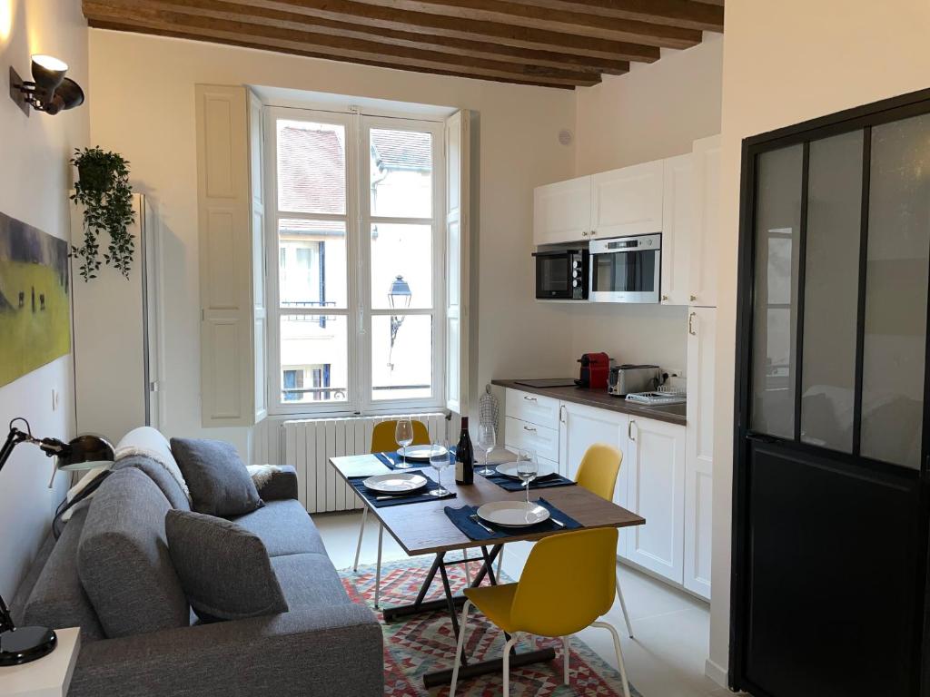 een woonkamer met een bank en een tafel bij Studio rénové et tres fonctionnel, Marly-le-Roi in Marly-le-Roi