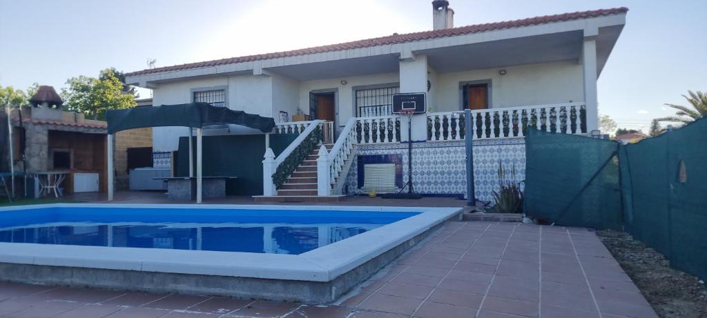 a house with a swimming pool in front of it at Villa los Cantos in Toledo