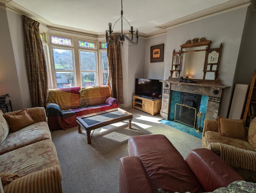 a living room with a couch and a fireplace at 5 bed terraced family home Bristol + parking in Bristol