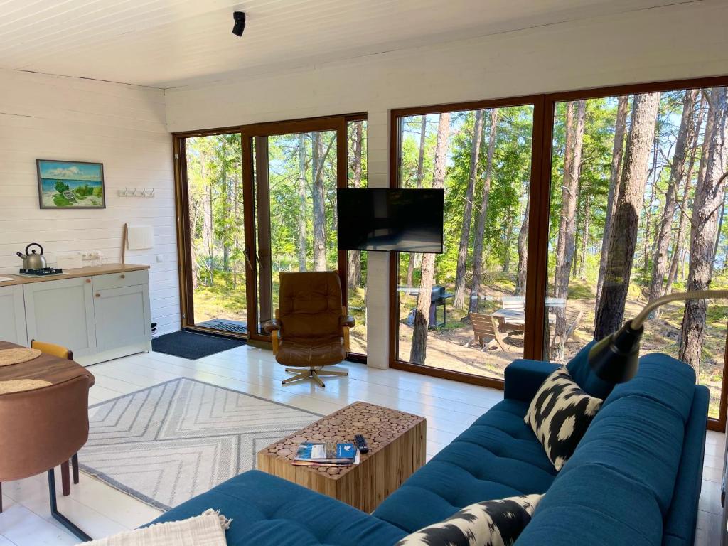 ein Wohnzimmer mit einem blauen Sofa und einem TV in der Unterkunft BEACH HOUSE HUBERT in Undva