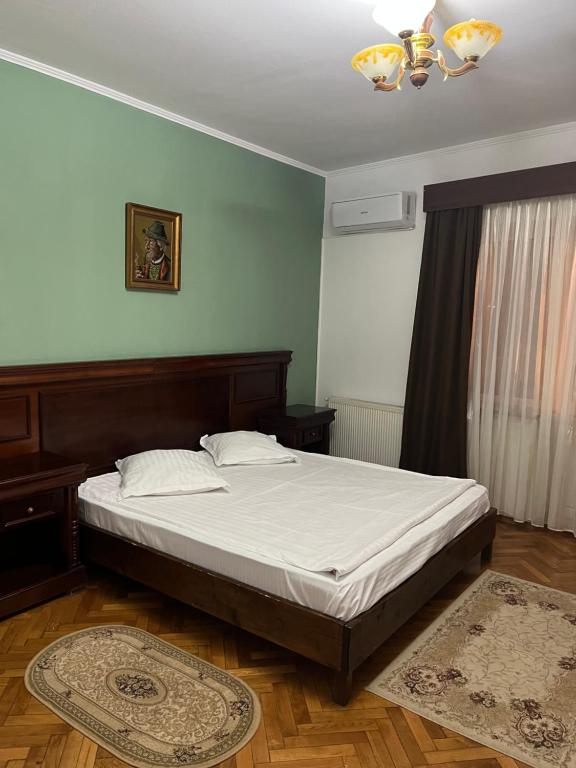 a bedroom with a large bed with white sheets at Pensiunea Diana in Făgăraş