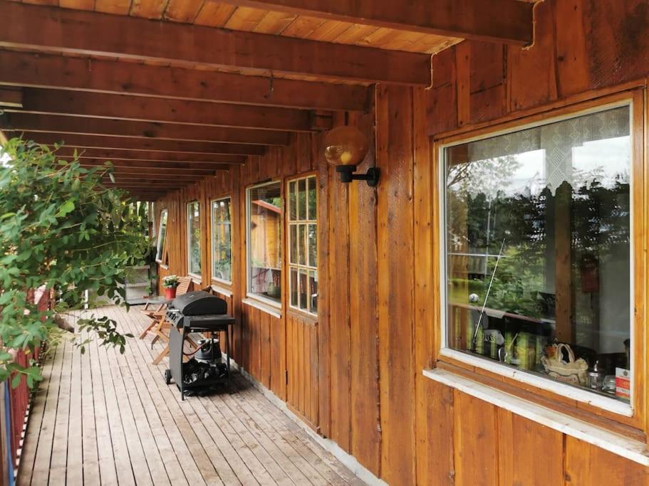 una veranda di una casa in legno con finestra di Loghouse apartment in arctic wonderland! a Kvaløya