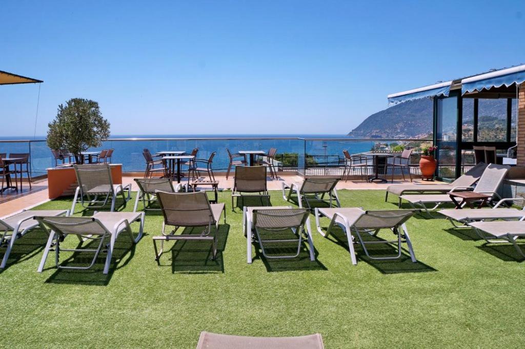 a group of chairs and tables on the grass at HOTEL VICKY II in Plomari