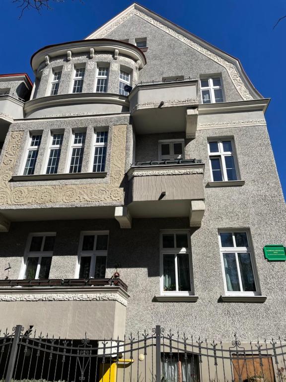 a large gray building with windows and a fence at Apartamenty i pokoje przy sopockim molo in Sopot