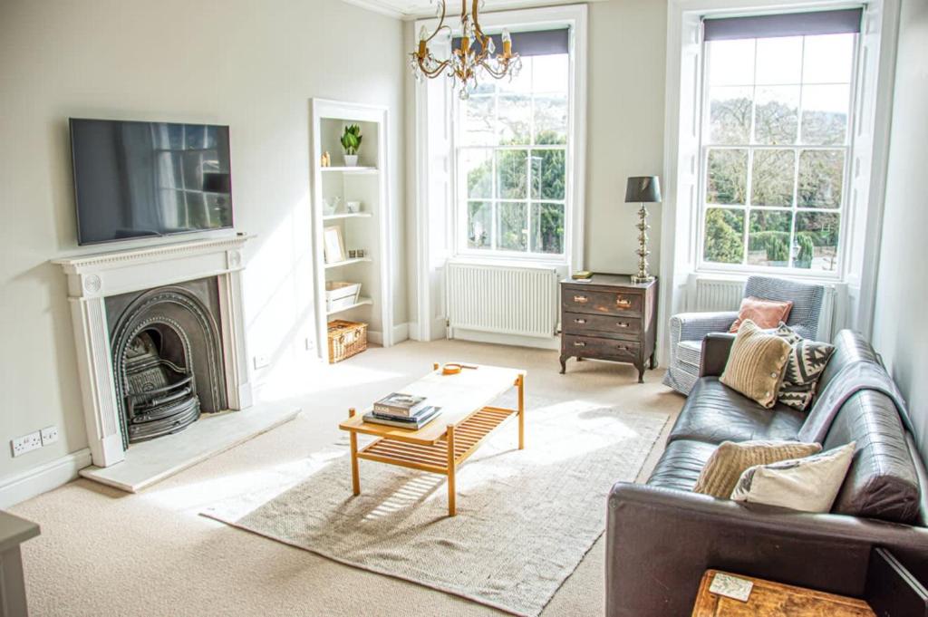 a living room with a couch and a tv at Beautiful Georgian One Bedroom Apartment in Bath