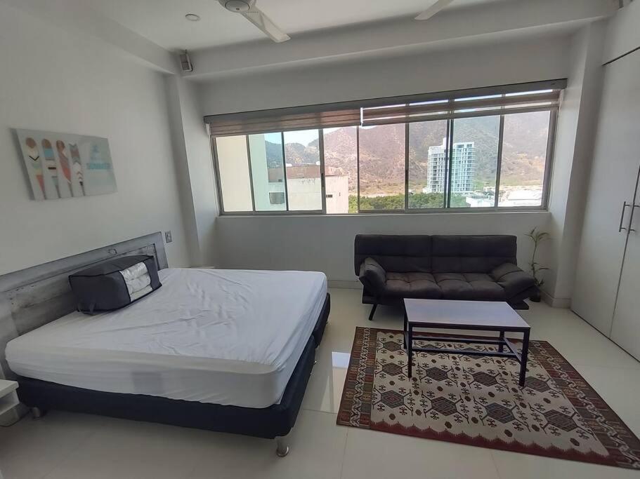 a small bedroom with a bed and a couch at Hugos studio loft in Gaira