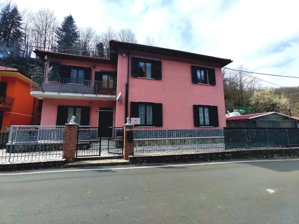 ein rosa Haus mit einem Zaun davor in der Unterkunft Il Ciliegio in Chiama