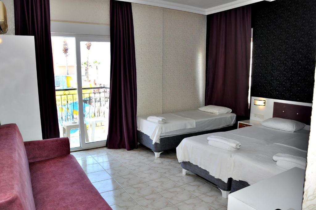 Postel nebo postele na pokoji v ubytování Saygılı Beach Hotel