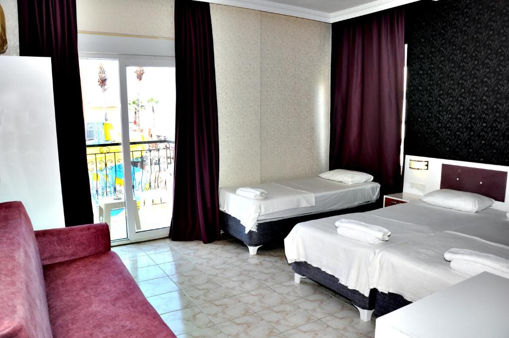 Postel nebo postele na pokoji v ubytování Saygılı Beach Hotel