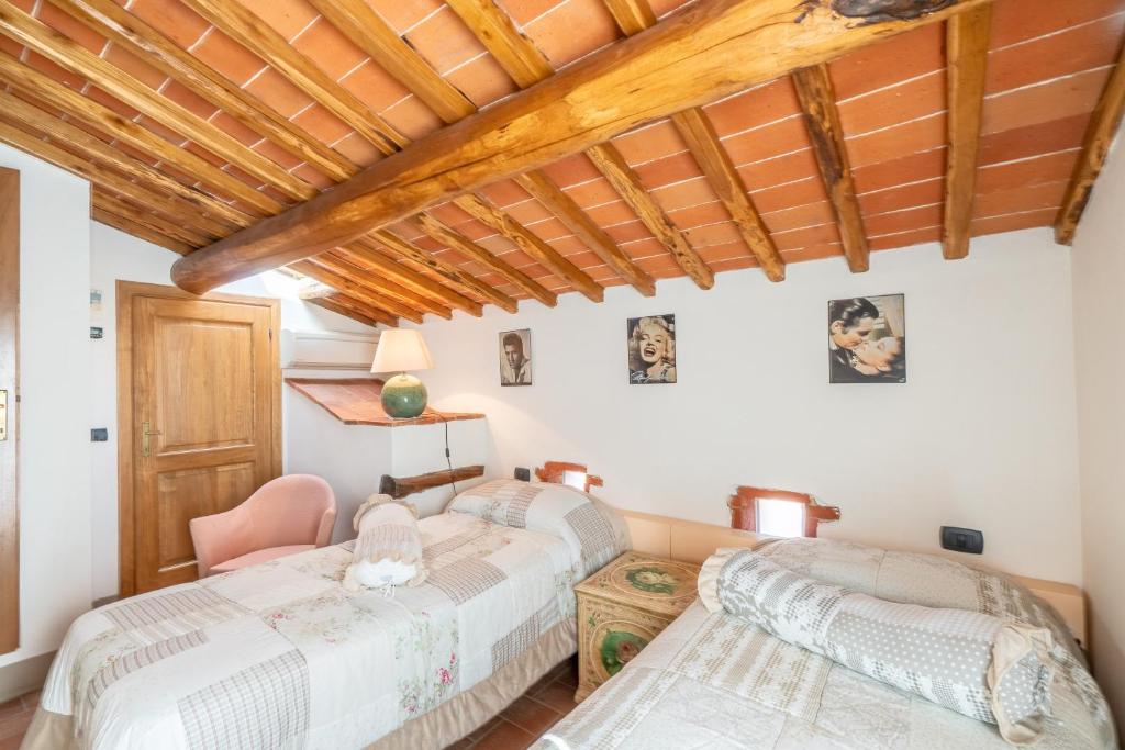 2 bedden in een kamer met houten plafonds bij Agriturismo Podere Luisa in Montevarchi
