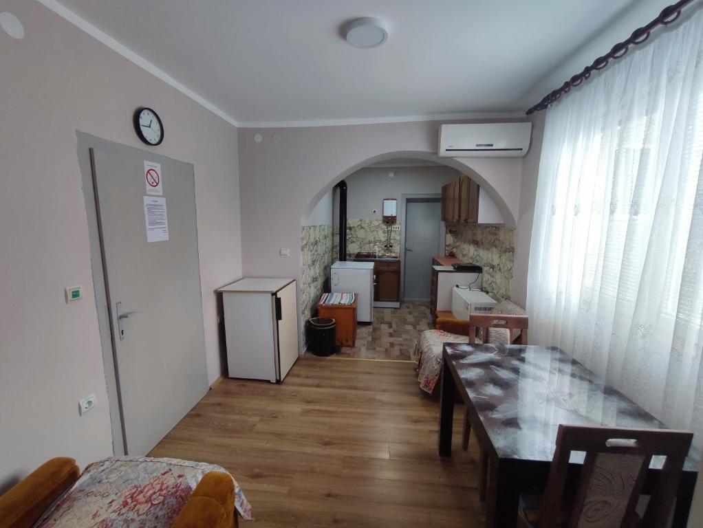 een woonkamer met een tafel en een keuken bij Apartman Kristina Ribarska banja in Kruševac