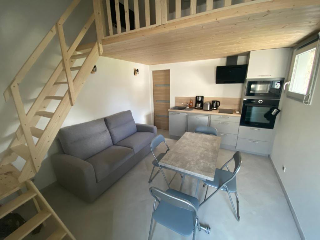ein Wohnzimmer mit einem Sofa, einem Tisch und Stühlen in der Unterkunft Chez Mongery in Landreville