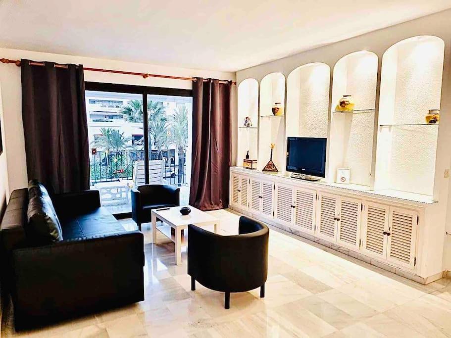 sala de estar con sofá y mesa en PUERTO BANUS, 2 ROOMS, POOL AND PRIVATE PARKING., en Marbella