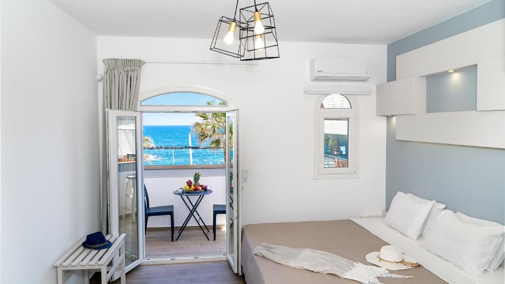 sypialnia z łóżkiem i widokiem na ocean w obiekcie Renata Mare Beachside Studios w mieście Hersonissos