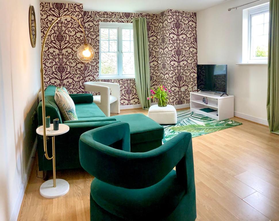 uma sala de estar com um sofá verde e cadeiras em The Comfy Flat- Modern & Bright 2 Bedrooms Apartment em Liverpool