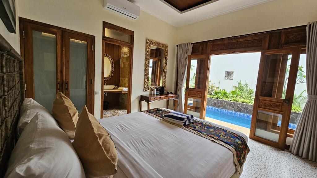 a bedroom with a bed with a view of a pool at Jepara Garden Resort in Jepara