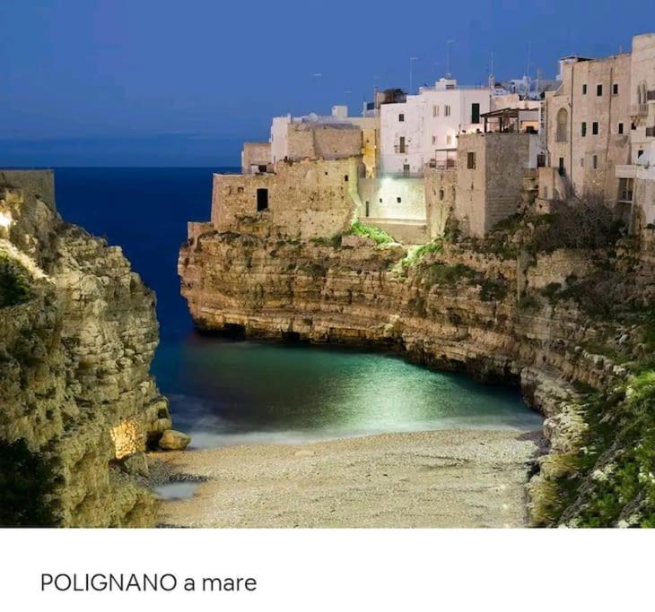 a large body of water with buildings on a cliff at Casa DOLCE PUGLIA Melograno in Castellana Grotte