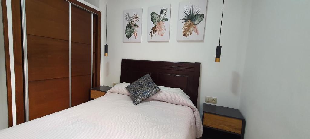 a bedroom with a bed and three pictures on the wall at Appartement au Centre de Martil in Martil