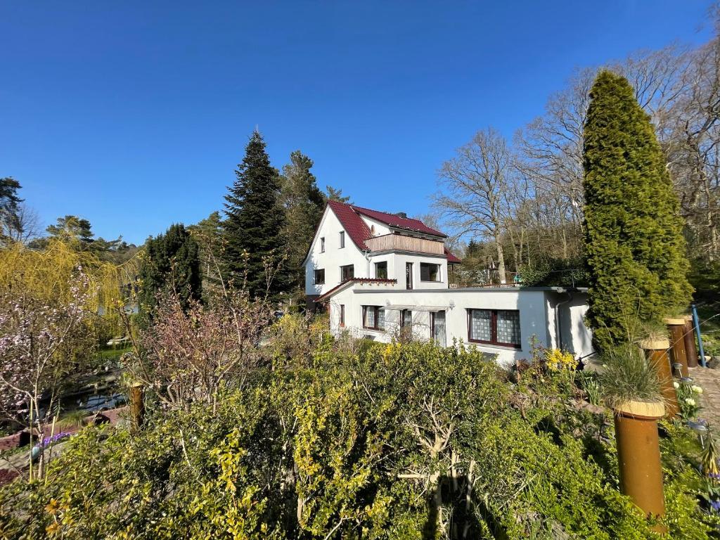 a white house on top of a hill with trees at Ferienwohnungen Rolinski in Lietzow