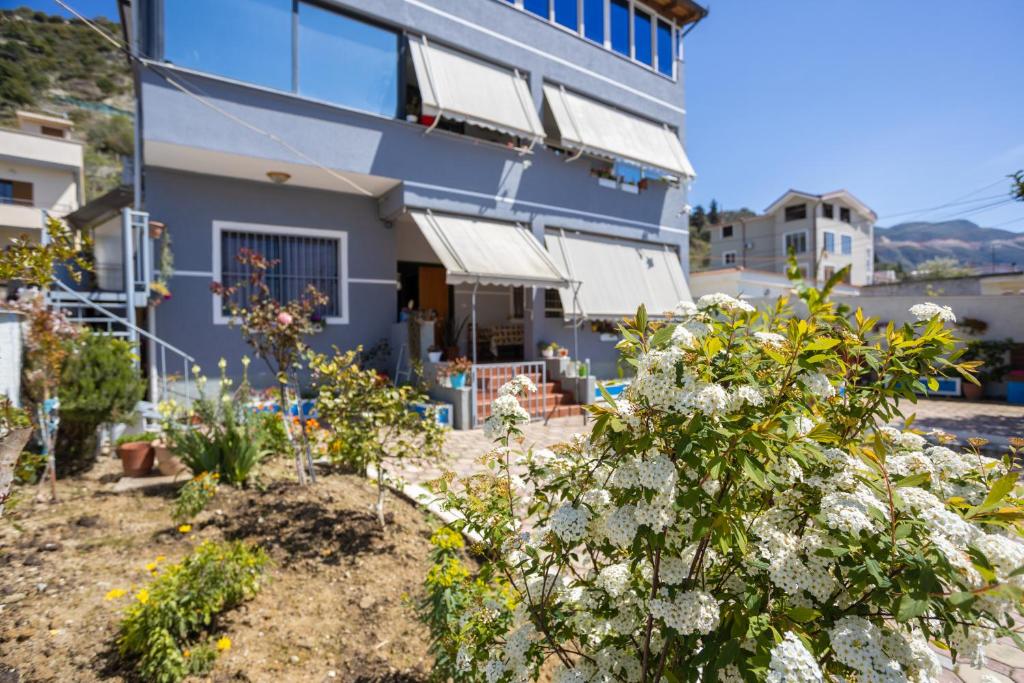 ein Haus mit Blumen vor einem Gebäude in der Unterkunft Vila AULONA in Vlorë