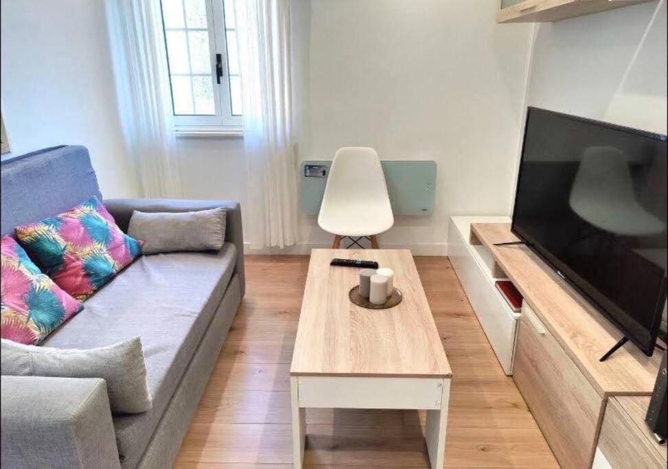 - un salon avec un canapé et une télévision dans l'établissement Apartamento Casa Davila, à Santander