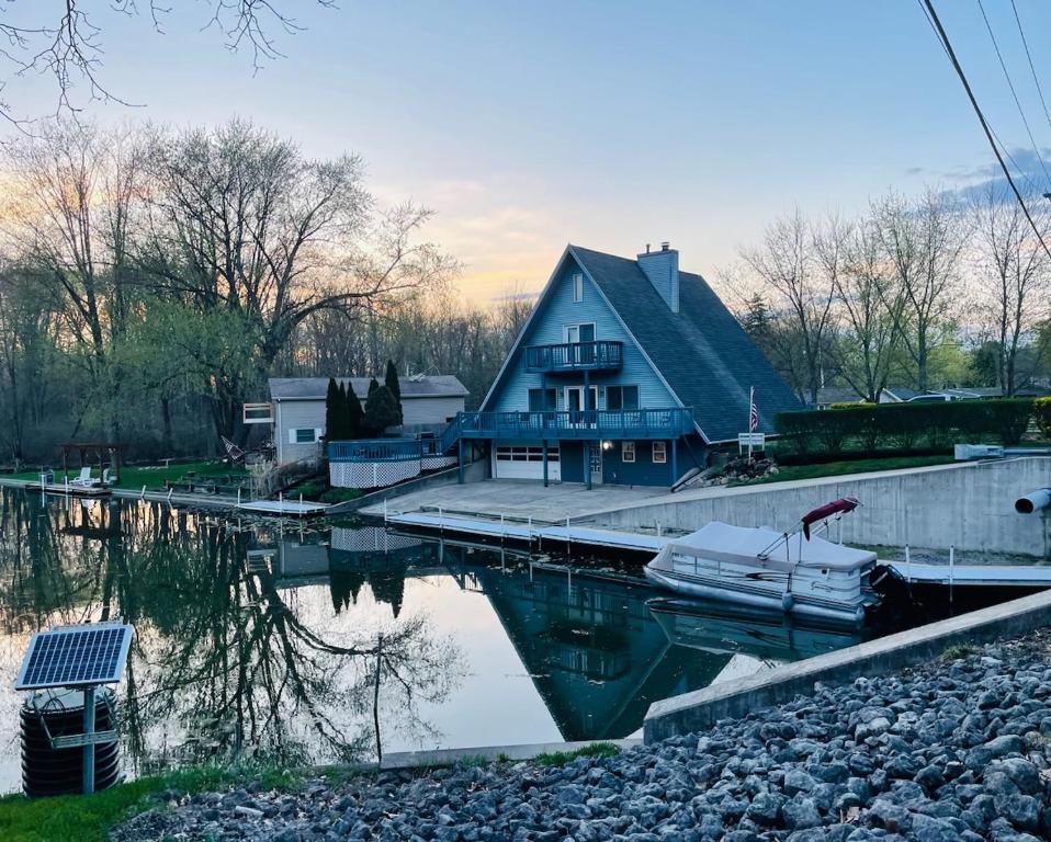 une maison avec un quai et un bateau dans l'eau dans l'établissement Channel Front A-frame Retreat, à Syracuse