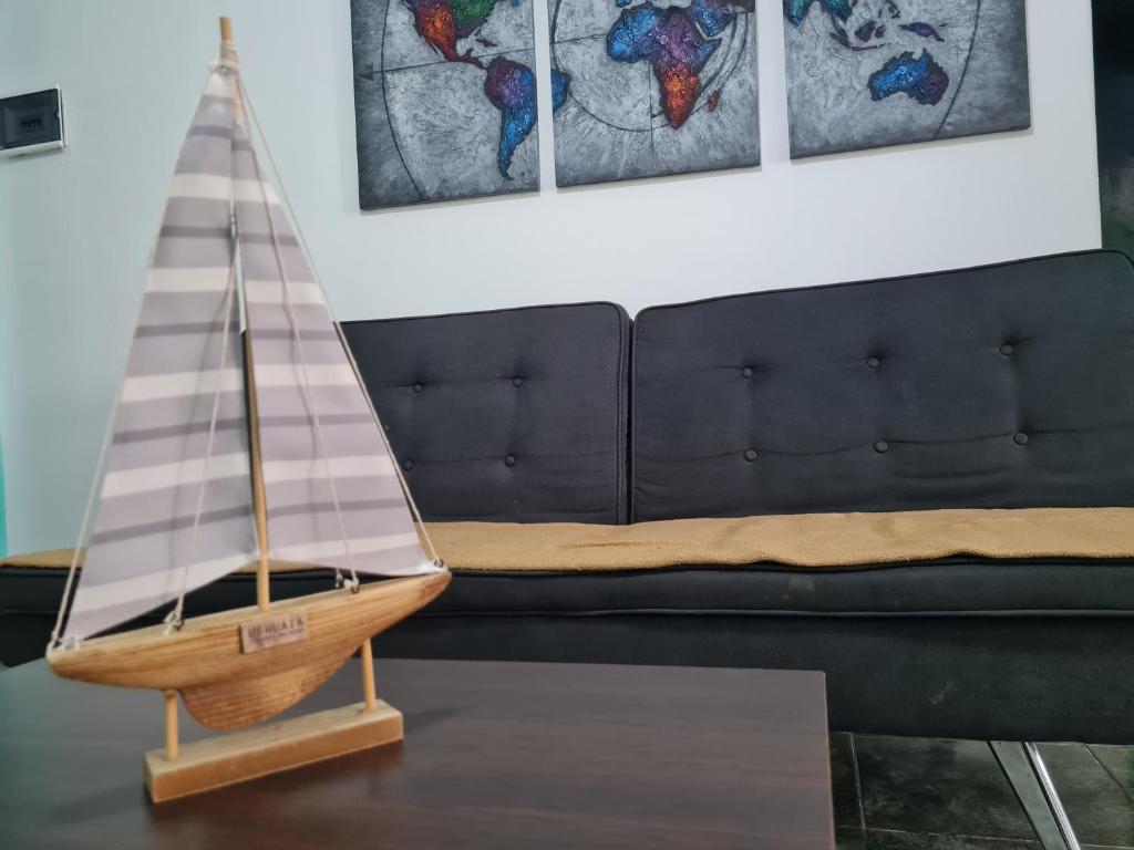a wooden sail boat on a table next to a couch at Casa a minutos del Aeropuerto in Ezeiza