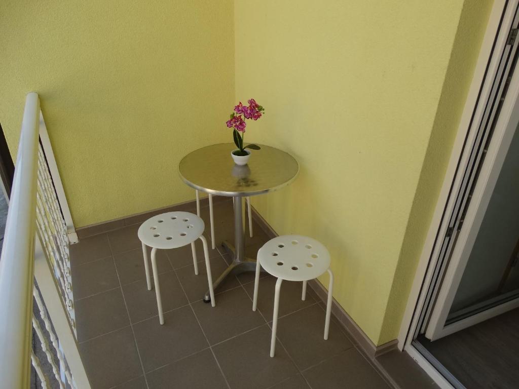 a table with two stools and a vase with flowers on it at Vila Jenic in Soko Banja