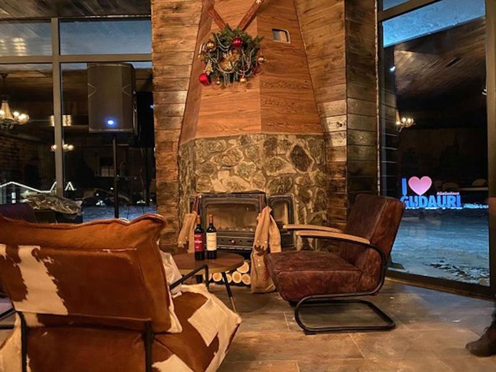 a living room with chairs and a stone fireplace at New Gudauri Atrium in Gudauri
