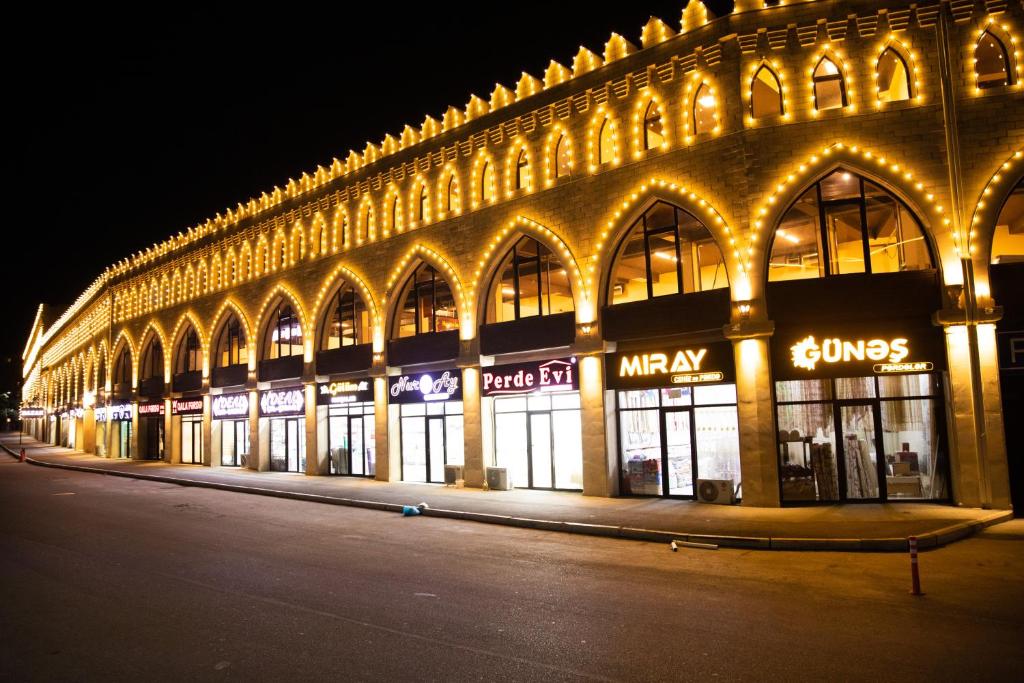 un gran edificio con luces encendidas por la noche en Qala Hostel Ganja, en Ganja