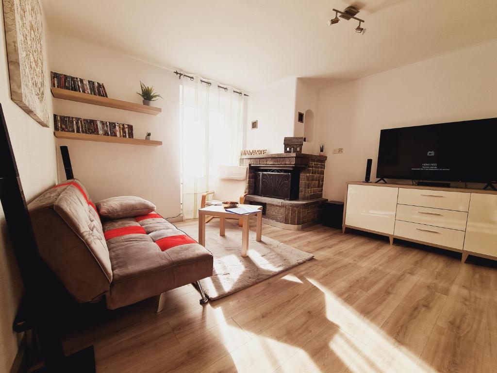 uma sala de estar com um sofá e uma televisão em Casa Rosina - Una caramella, nel nucleo, ai piedi della Verzasca- em Gordola