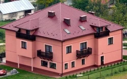 um grande edifício rosa com um telhado vermelho em Holica em Krynica-Zdrój