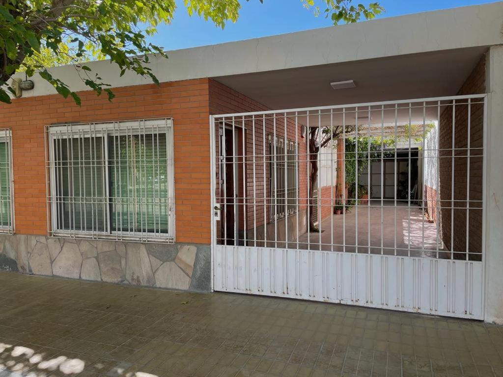 um portão em frente a uma casa com um edifício em El Rosario em Pocito